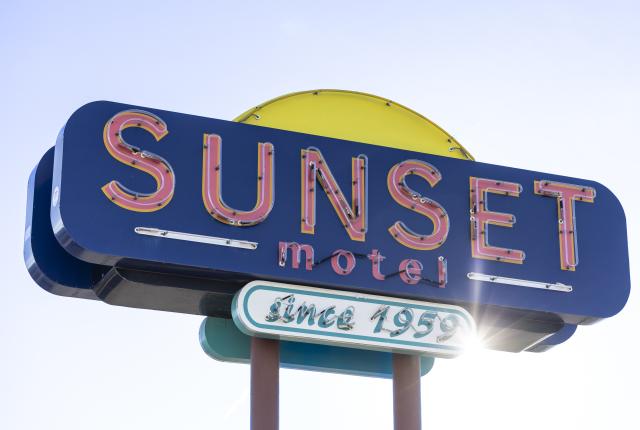 Vintage Sunset Motel neon sign along Route 66 in Central New Mexico, featuring retro colors and design.