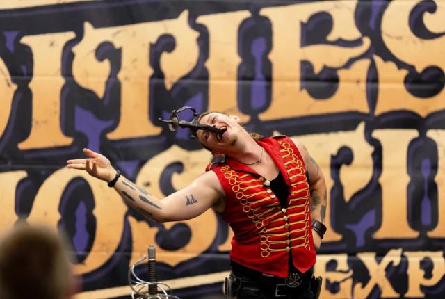 A sideshow performer swallows a sword at the Oddities & Curiosities Expo.