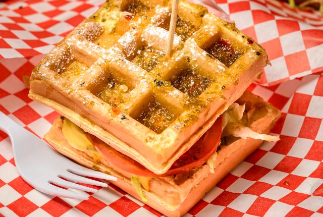 A green chile cheeseburger stacked between Belgian waffles, topped with syrup and powdered sugar at the New Mexico State Fair Unique Foods Contest.