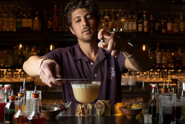 Bartender Andy Pollack crafts a golden cocktail at Milk of the Poppy in Santa Fe.