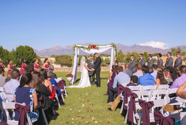 Outdoor wedding ceremony under a bright blue sky.