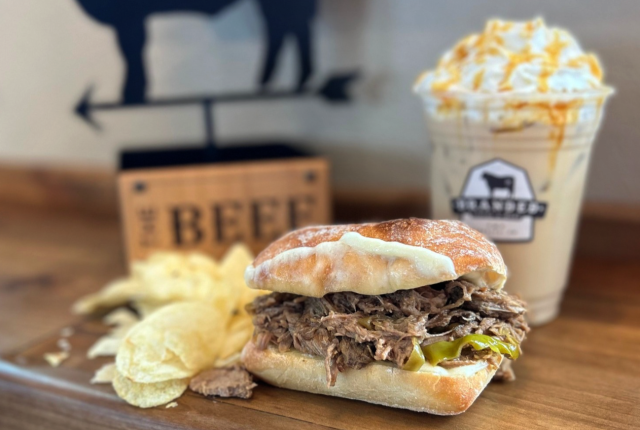 Pepperoncini sandwich and blended coffee drink on a wooden table.