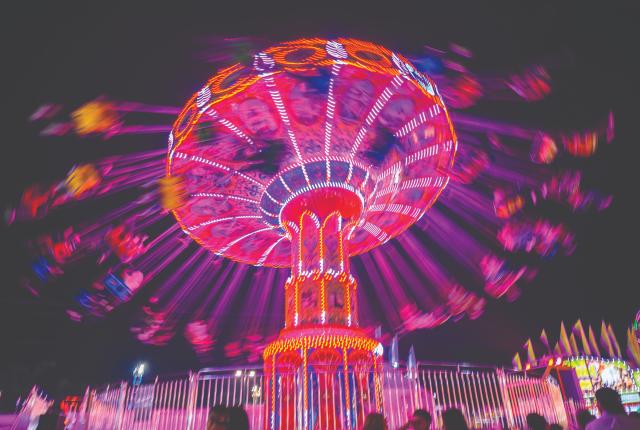 The Wave Swinger lights up the midway at the New Mexico State Fair.