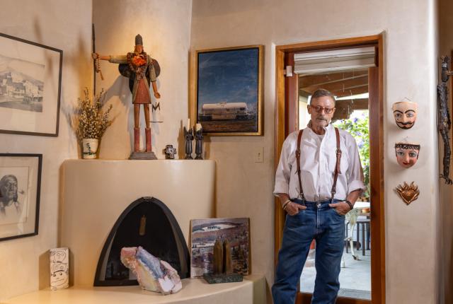Writer Steve Cantrell stands in his New Mexico home surrounded by artworks.