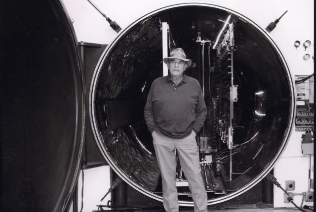 Larry Bell stands beside the open circular chamber of the Tank in his Taos studio.