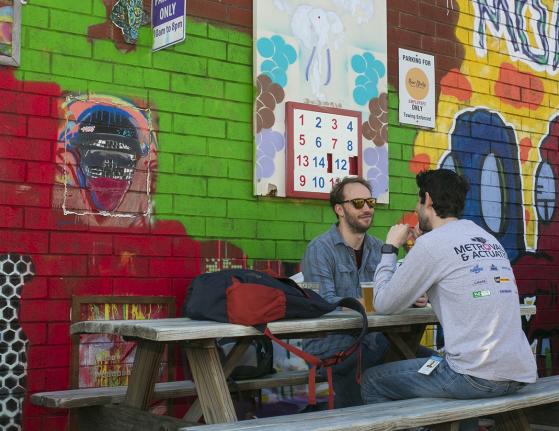 People sitting at Picnic Table Midway Mural on Graham St
