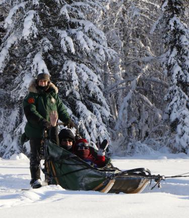 Two people riding in a sled at Paws for Adventure