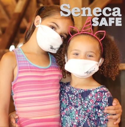 Two young girls wearing masks