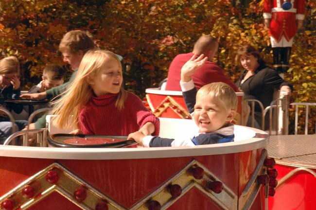 Santa's Village Drummer Boy Teacup Ride (Two Kids Smiling and Waving on Ride)