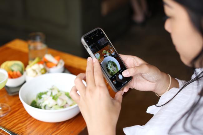 Woman taking photo of pho before eating