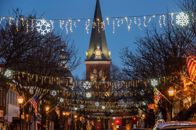 lights strung across a city street with a historic church in the background at night
