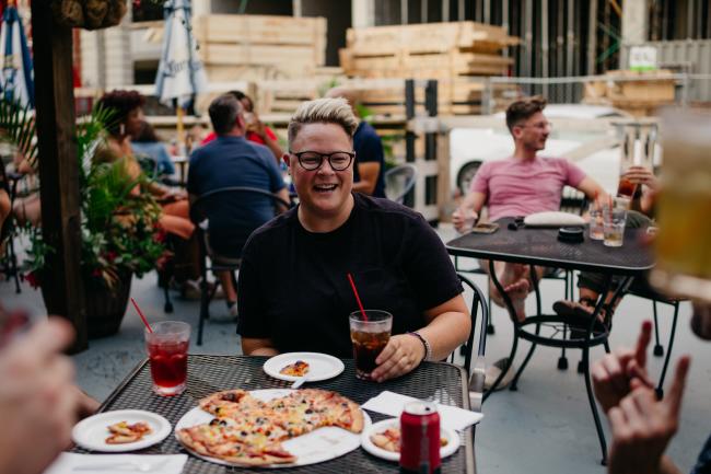 Woman eating Columbus-Style Pizza at Slammers in Columbus
