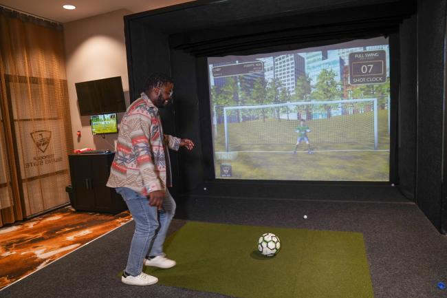 Man playing soccer at Top Golf Suite