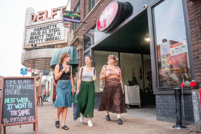 Three college students walking down Washington St. with coffees