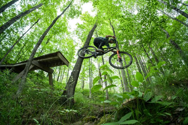 Mountain biker Brice Shirbach going off a jump on the NTN North Trails in Marquette, MI