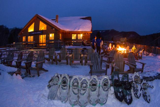 Loon Mountain - Snowshoes Lined Up in Front of Fire with Building in Background (Exterior Photo, Evening)