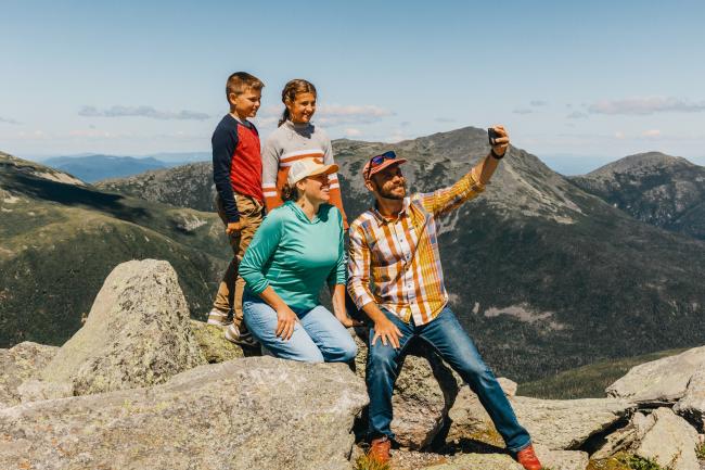 Mt. Washington Auto Road (Family Taking a Selfie with View of Mountains Behind Them)