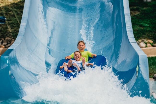 Whale's Tale Waterpark - two boys riding a tube down a waterslide