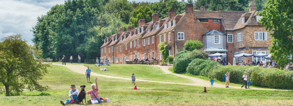 Bucklers Hard village from the river with people walking around in the summer in the New Forest