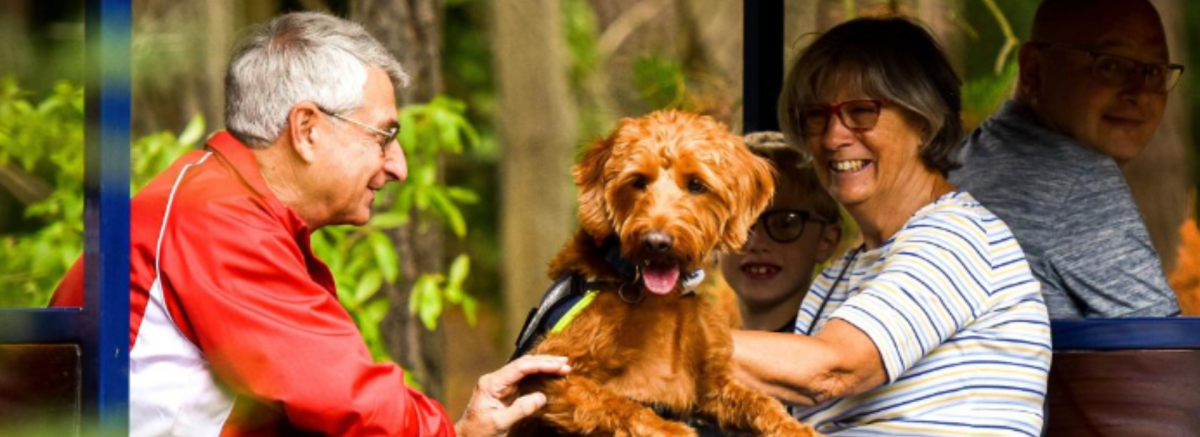 Man and woman on steam railway at Exbury Gardens with their dog