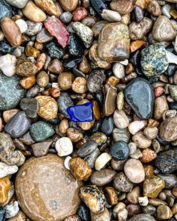 Blue beach glass in rocks by Charlotte Hernandez