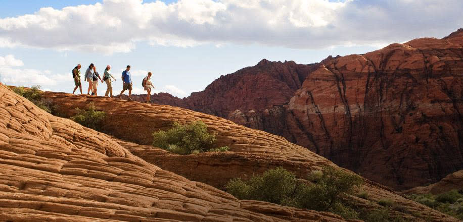 Group hiking on red rock in Southern Utah