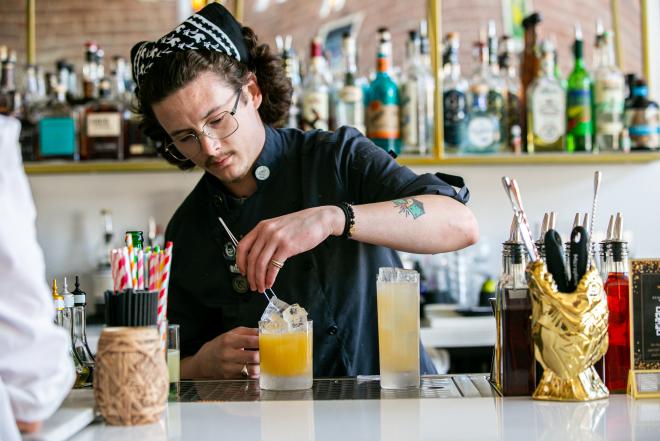 Bartender garnishes cocktail drink
