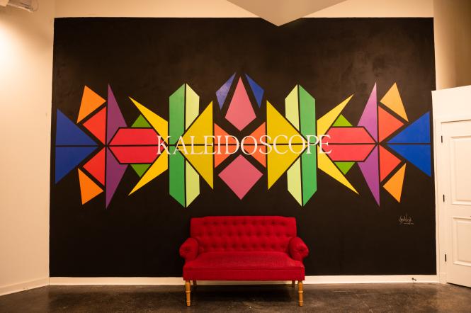 Kaleidoscope mural behind a red velvet couch