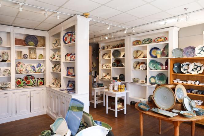 The shelves of The Annapolis Pottery are stocked with plates and pottery.