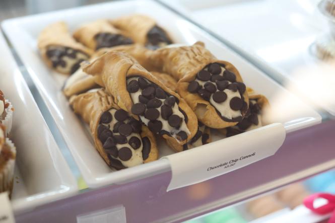 Chocolate chip cannoli in a display case at Sweet Eden Bakeshop.