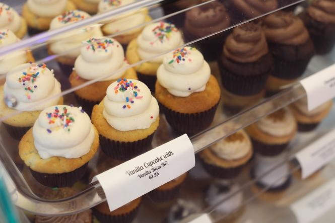 Chocolate and vanilla cupcakes in a display case.