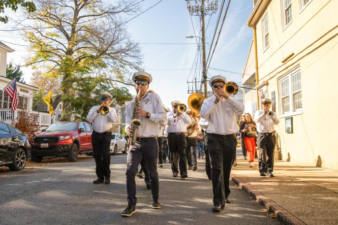 a brass band plays while marching down a street