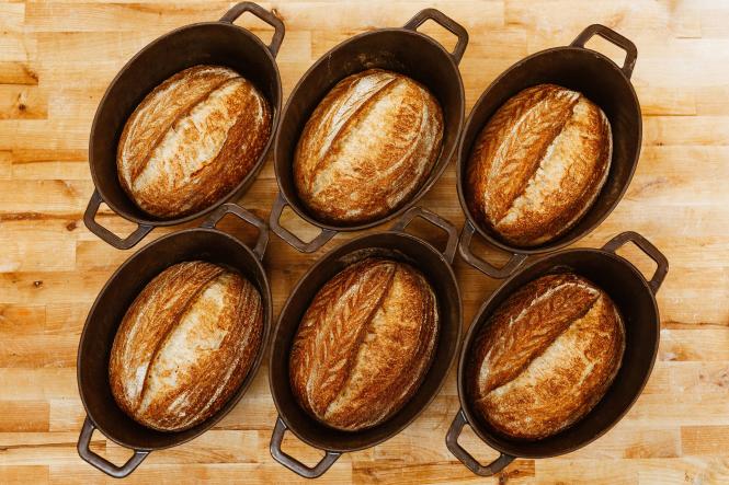 6 loaves of freshly baked bread sitting in their baking tins