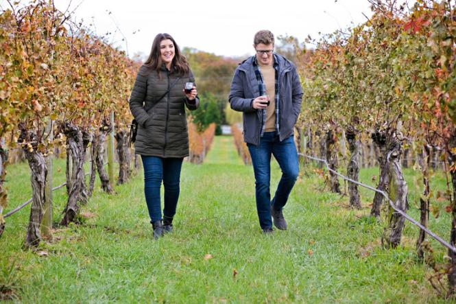 A man and woman stroll through the vineyard