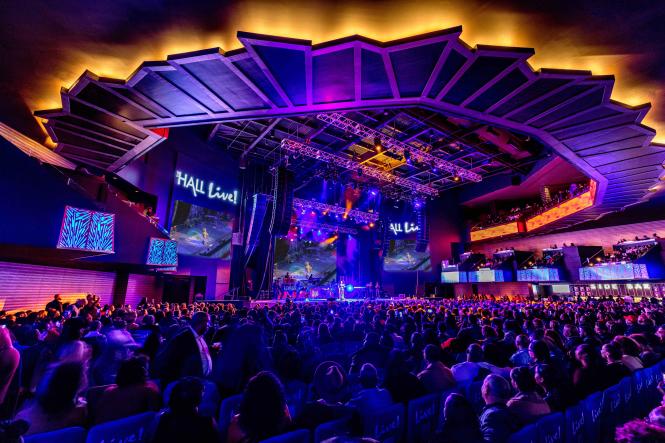 The concert hall with people in the audience and performers on stage