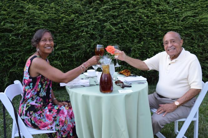 An African American couple toast to their dinner in the Paca Garden