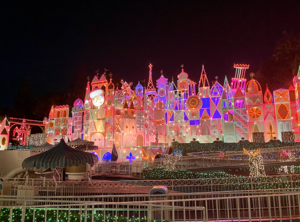 Image of the the it's a small world attraction at Disneyland lit up for the holidays.