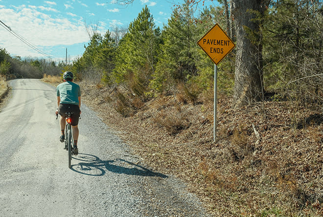 Gravel cyclist in Botetourt County with pavement ends highway sign