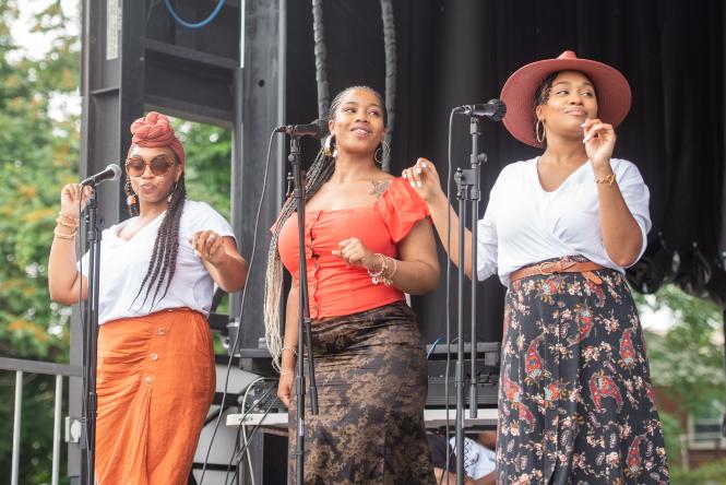A group of black women singing on a stage