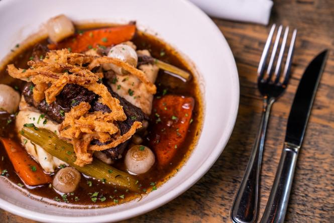 braised short ribs served over veggies with crispy onions on top.