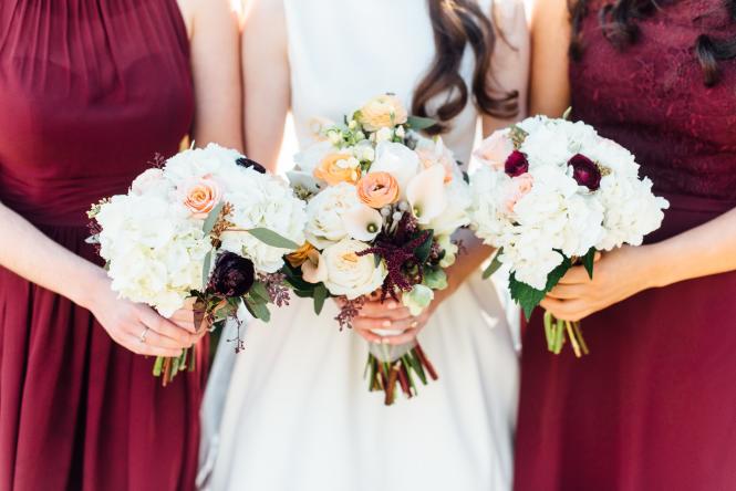 The bride and bridesmaids show off their bouquets.
