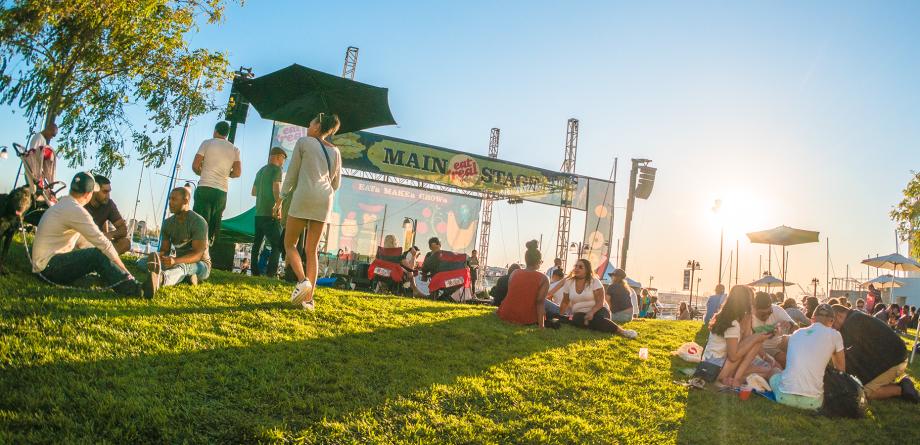Oakland visitors sitting on the lawn in front of the Main Stage