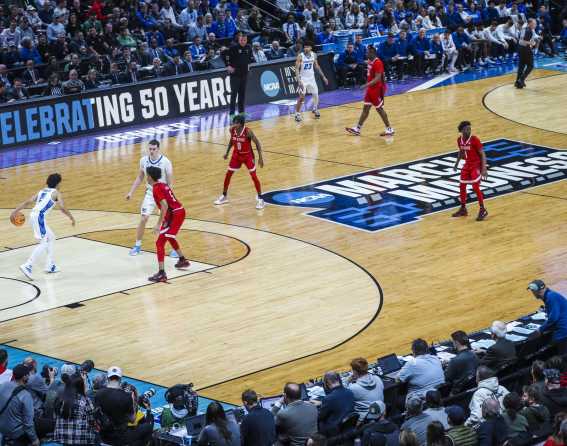 Basketball players move along the court at the NCAA Men’s Basketball Championships in 2025