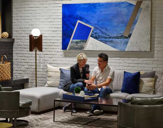 A couple is sitting on a sofa in the Halcyon hotel lobby in Denver, Colorado.