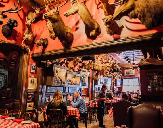 People sit at a table surrounded by taxidermy at Buckhorn Exchange