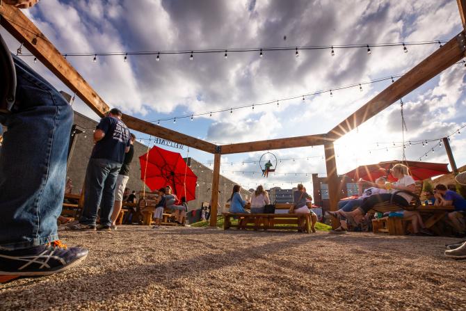 People sit on benches in the beer garden while drinking freshly brewed beers from Nortons Brewing Co
