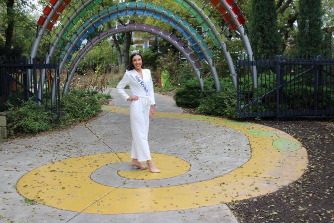 Miss Kansas poses beneath metal arches at Botanica Wichita