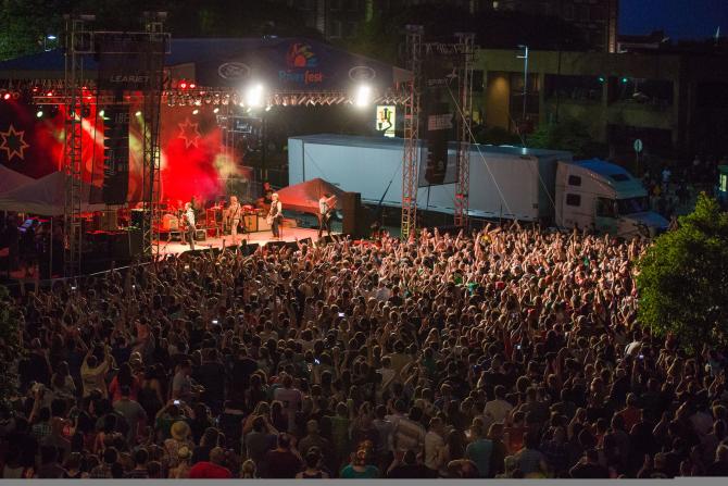 Flogging Molly perform at the Wichita Riverfest in front of a large crowd outdoors