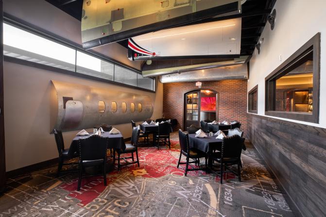 A private dining space is set up with four tables with black tablecloths and white napkins at Scotch & Sirloin in Wichita, KS