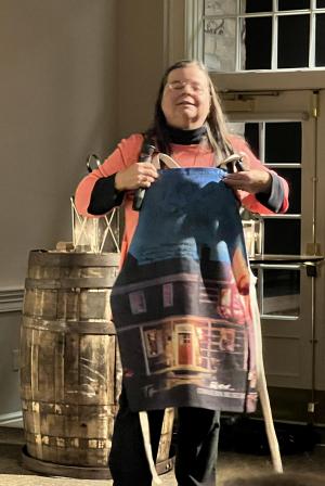 Theresa Gay Rohall shows off an apron autographed by Christian Bale and Kris Peck from "The Pale Blue Eye."